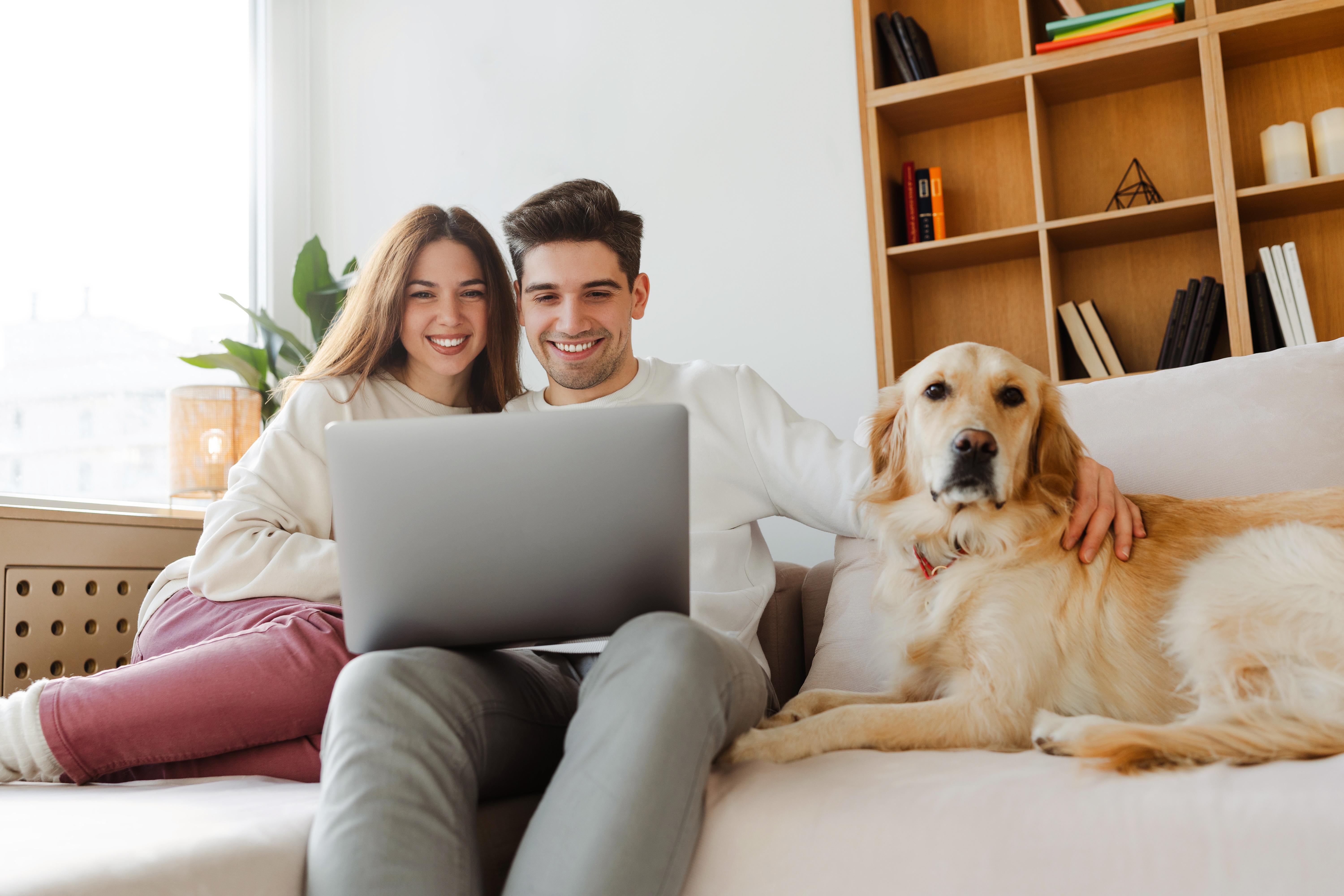 A young couple looking at a laptop and smiling