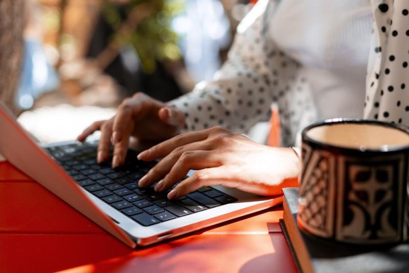 Typing on a laptop at a table.